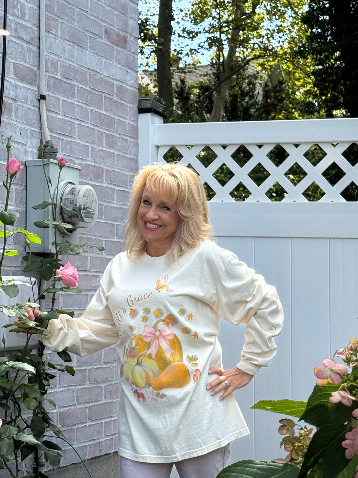 Customer wearing the Fall’s Grace pumpkin long-sleeve tee outdoors